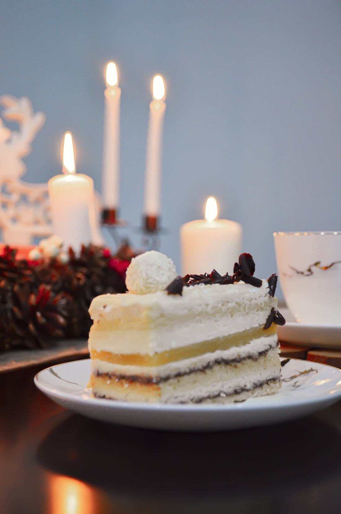 a piece of cake on a plate with candles in the background