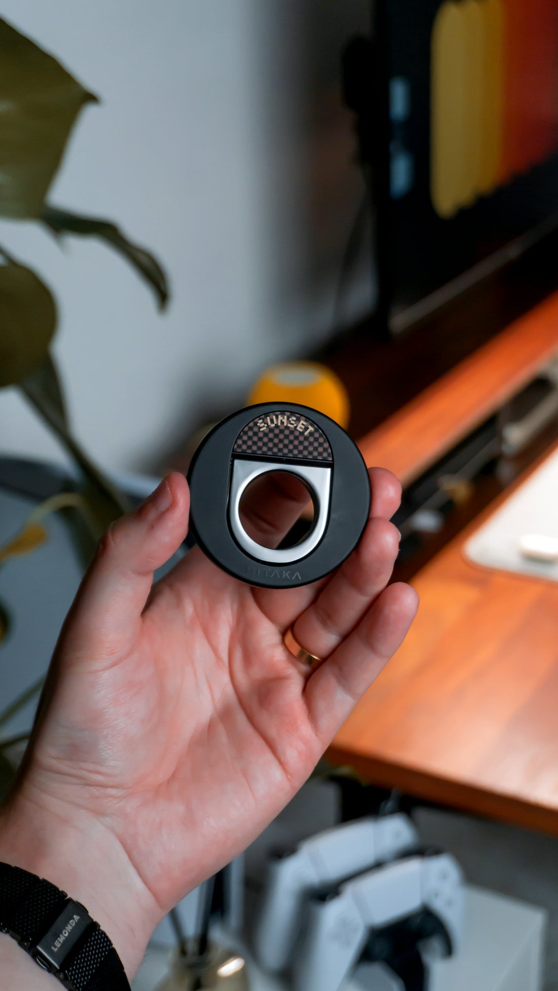 A hand holding a phone ring grip accessory.