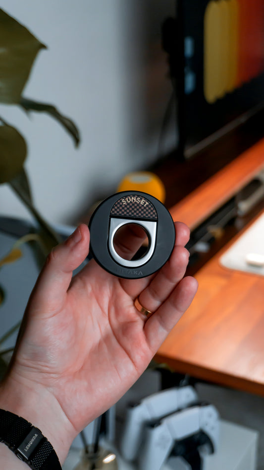 A hand holding a phone ring grip accessory.