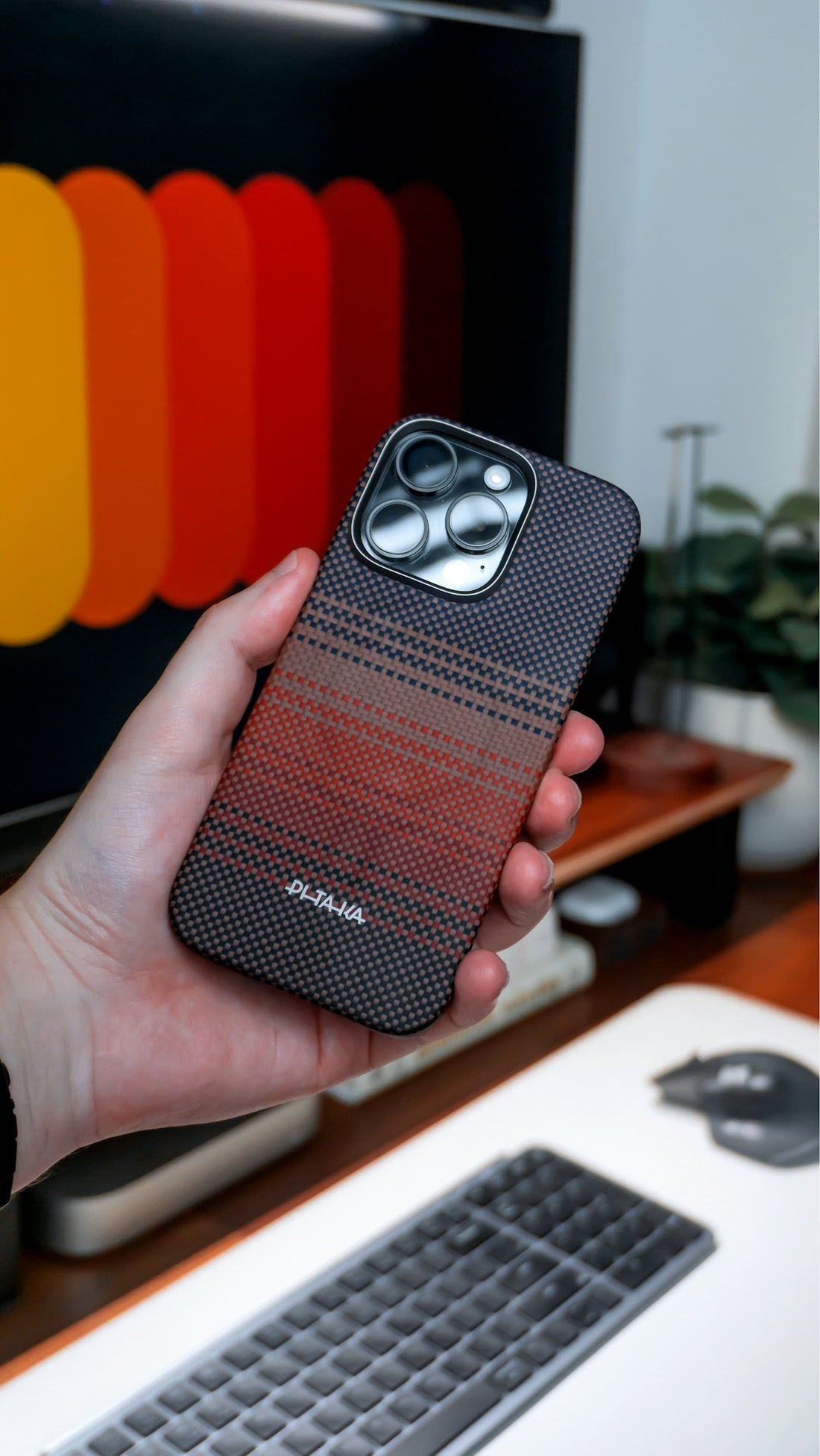 A hand holds a phone with a stylish patterned case.