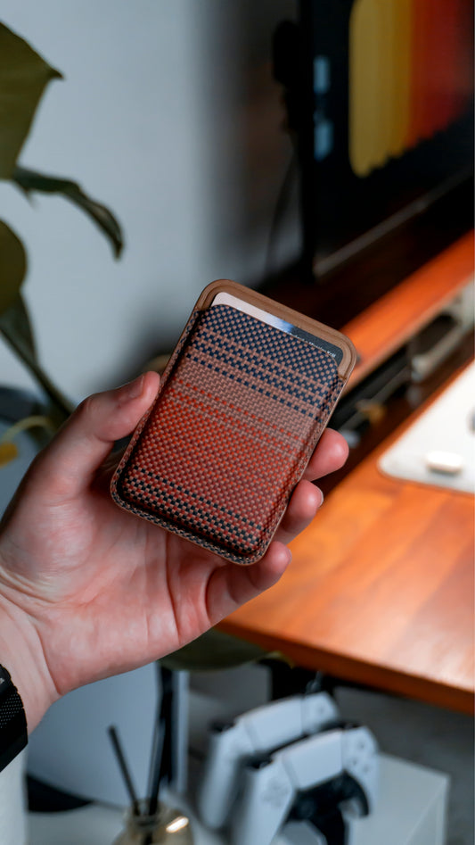 A hand holds a leather phone wallet.