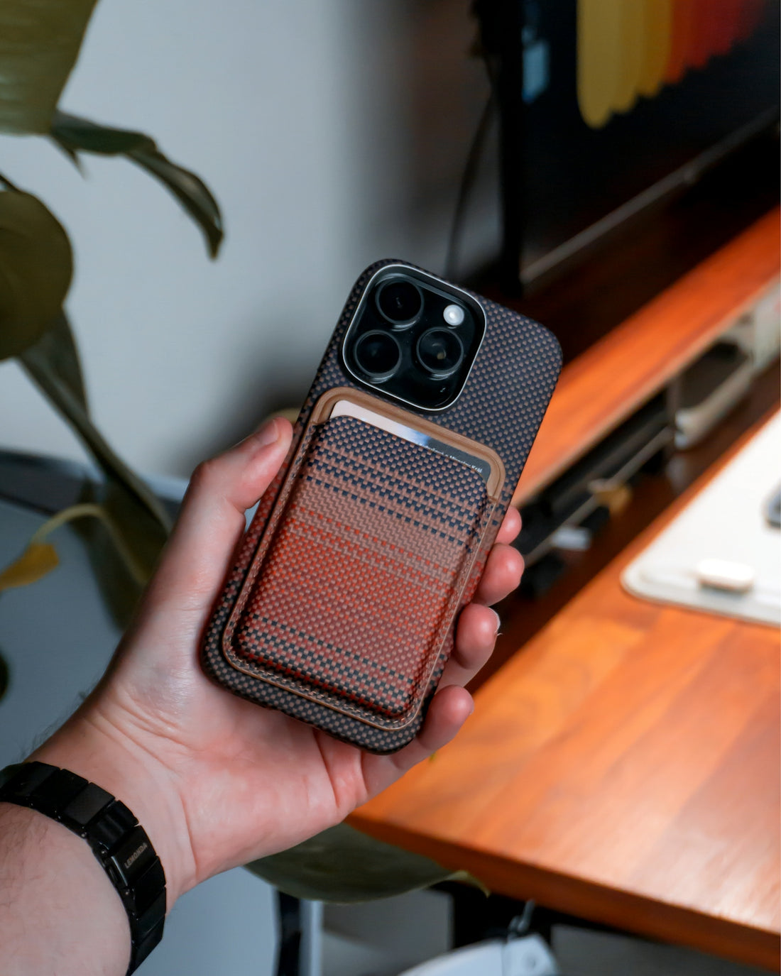 Person holds a phone with a wallet attachment.