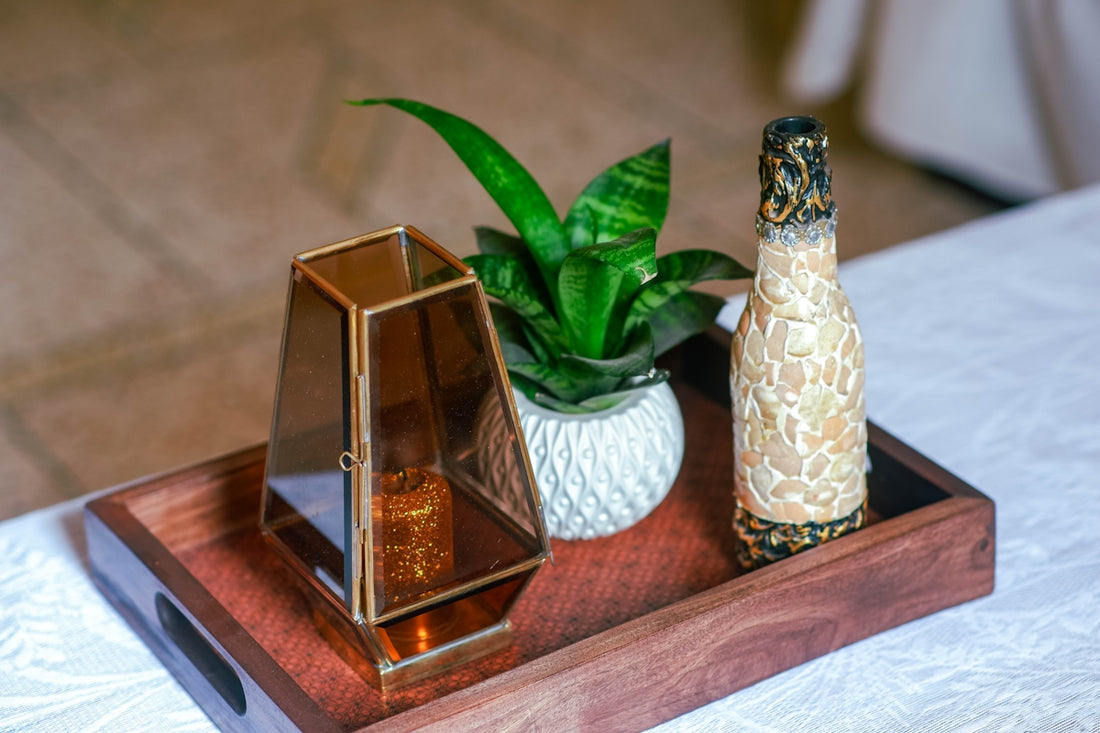 Decorations on a wooden tray with a candle and plant.