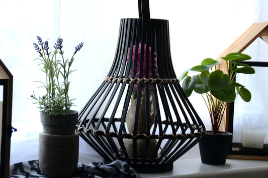 Black lantern with plants and candle on windowsill