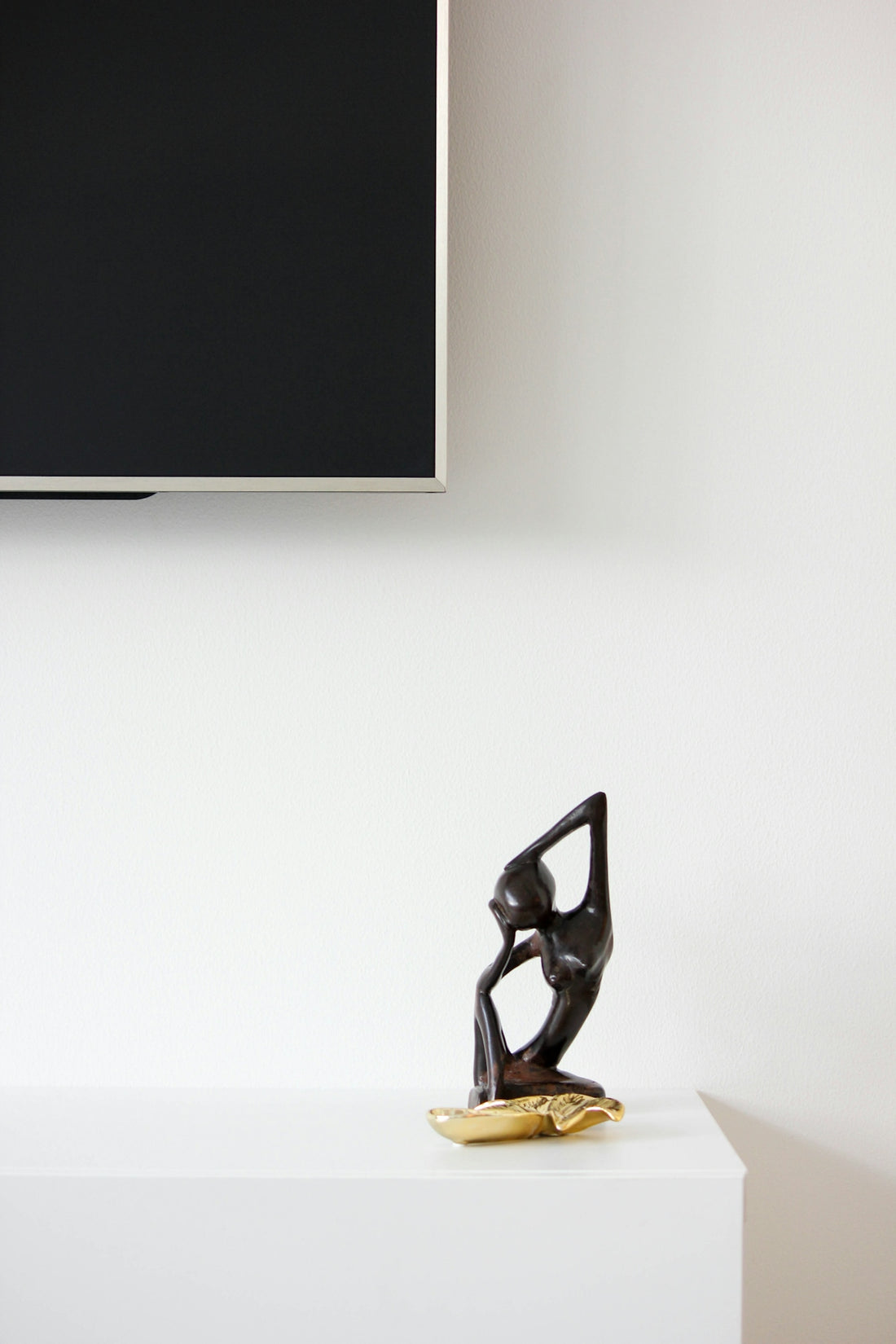 Wooden sculpture of a person on a shelf
