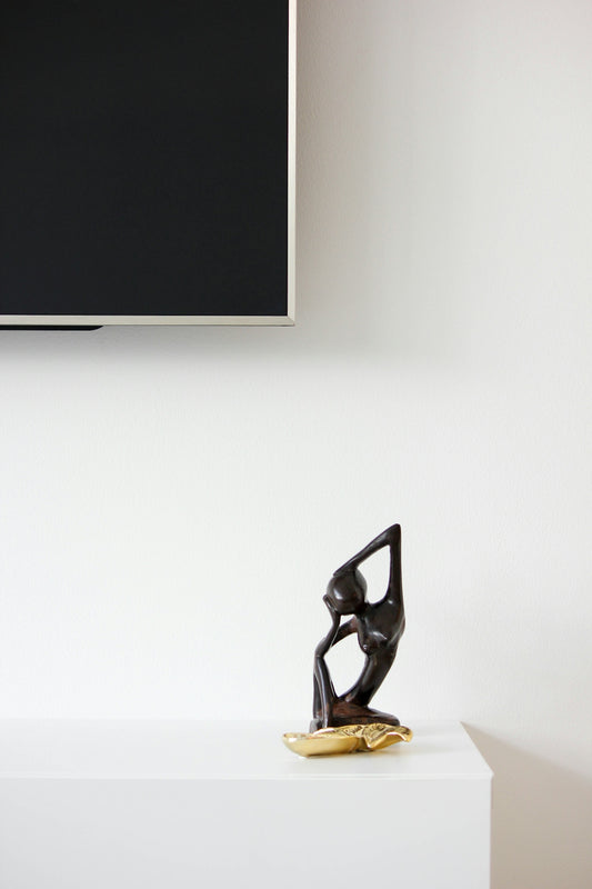 Wooden sculpture of a person on a shelf